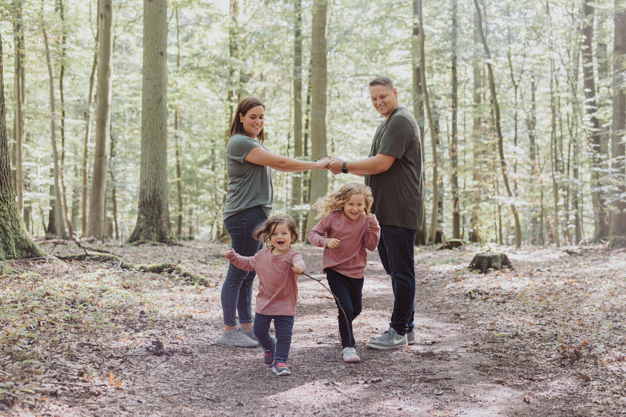 Familie umarmt sich lachend in einer sonnigen Wiese