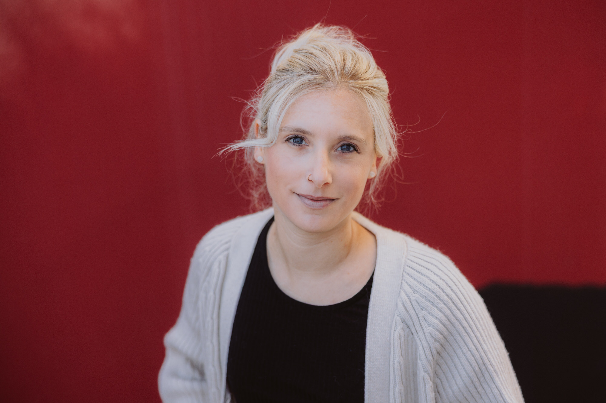 Portrait einer jungen Frau mit blauen Augen und blonden Haaren im losen Dutt